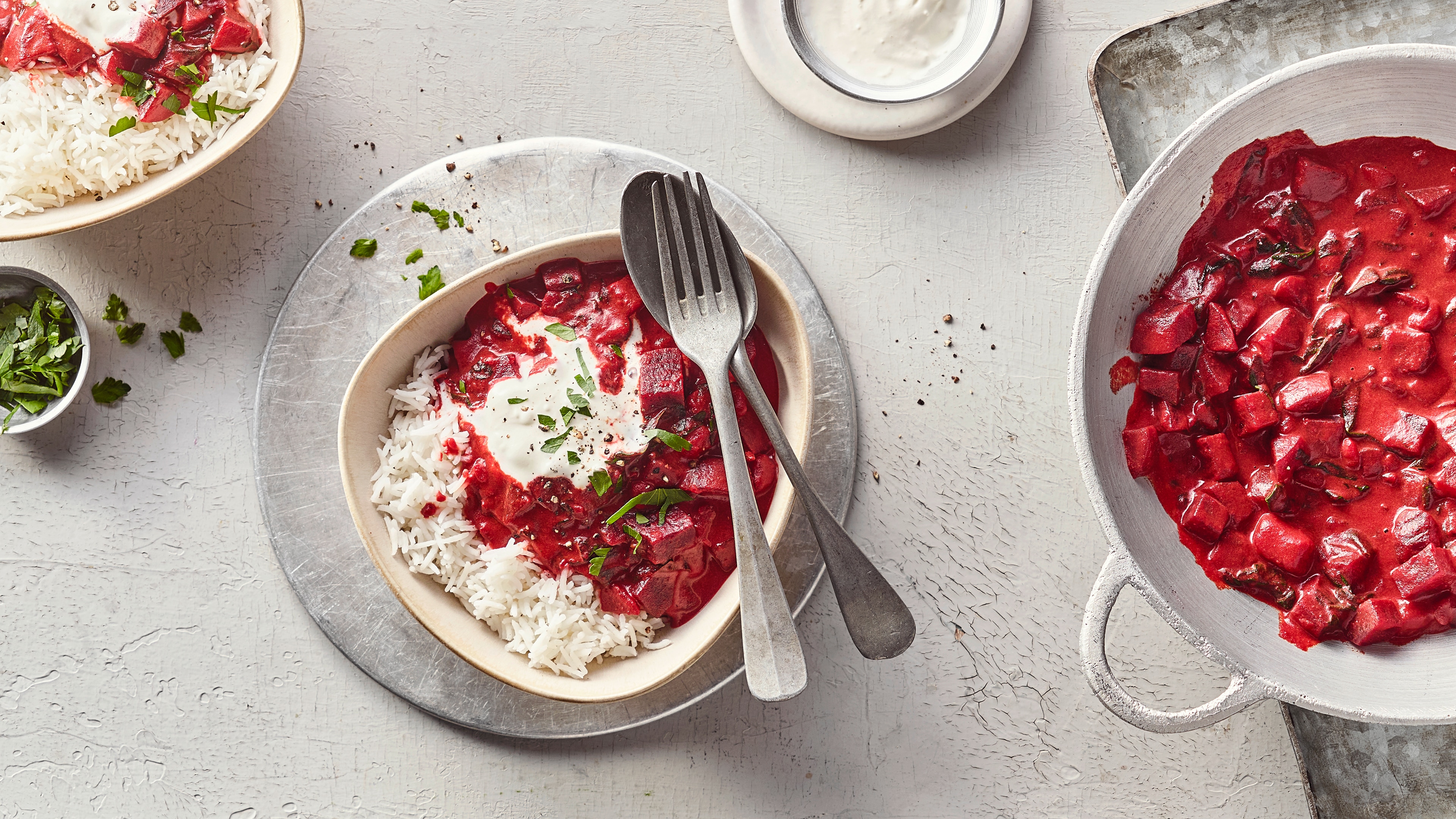 Eine Schale mit Reis und einer roten Sauce mit Rote-Bete-Stückchen, getoppt mit einem Klecks weißer Creme