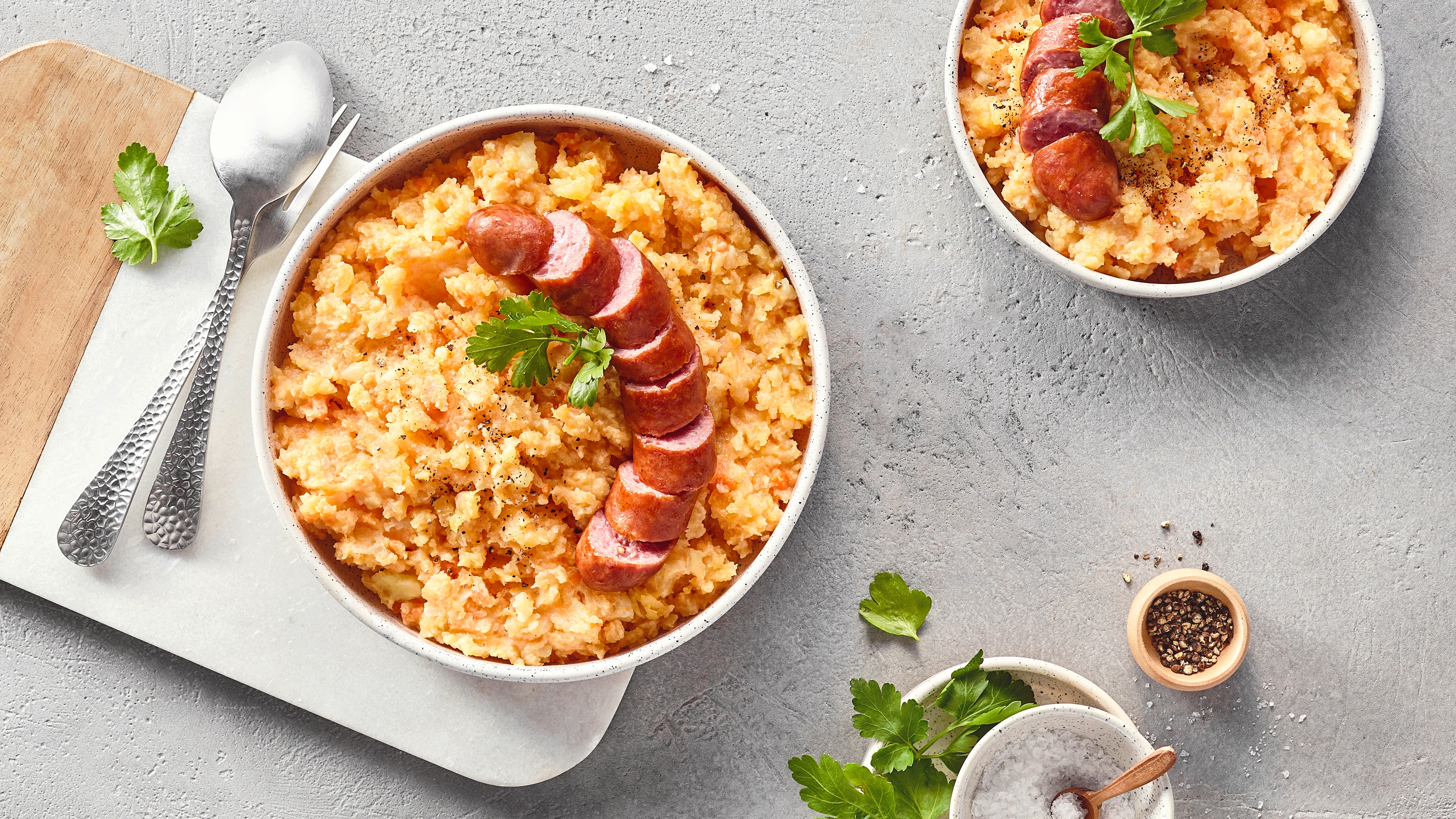 2 Schalen mit grobem Mus, darauf jeweils Wurstscheiben