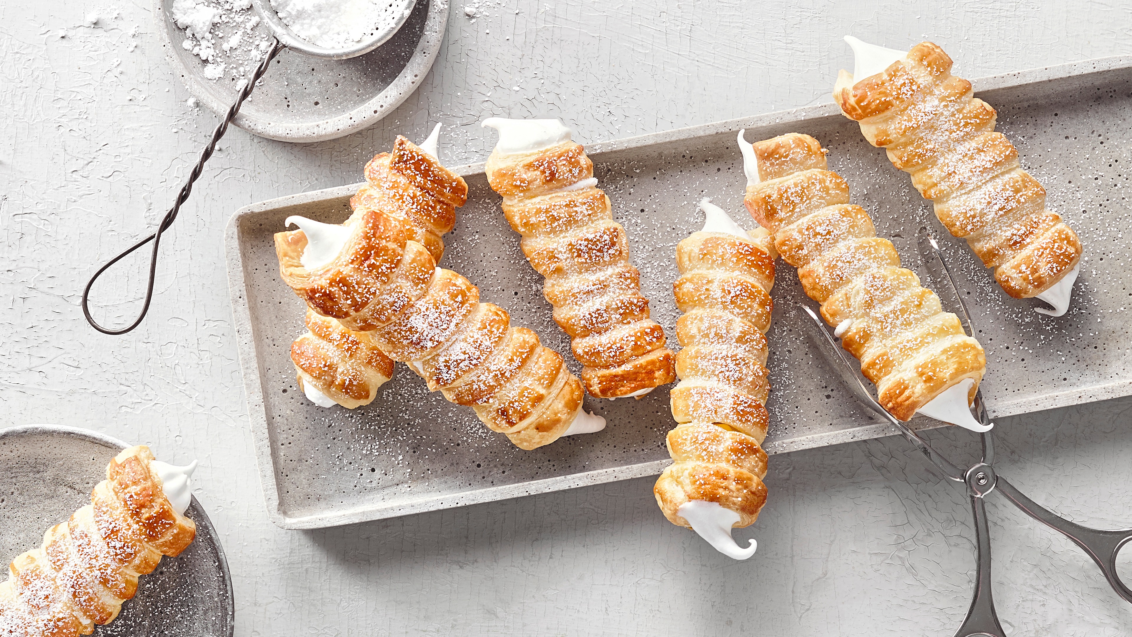 Knusprige Schaumrollen aus goldenem Blätterteig, gefüllt mit luftiger, weißer Vanillecreme.