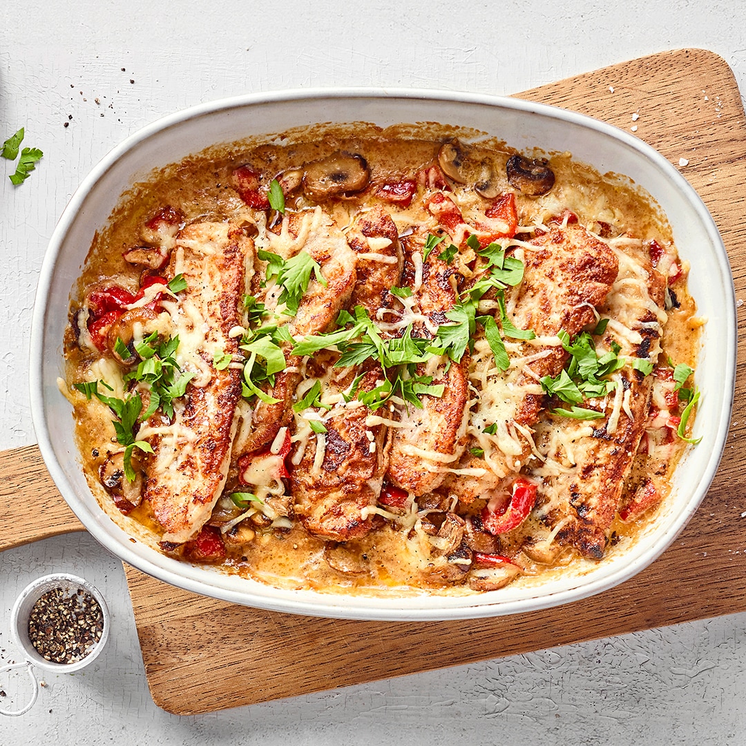 Schnitzelauflauf mit panierten Schnitzelstücken, cremiger Sauce, Gemüse und geschmolzenem Käse, goldbraun überbacken.