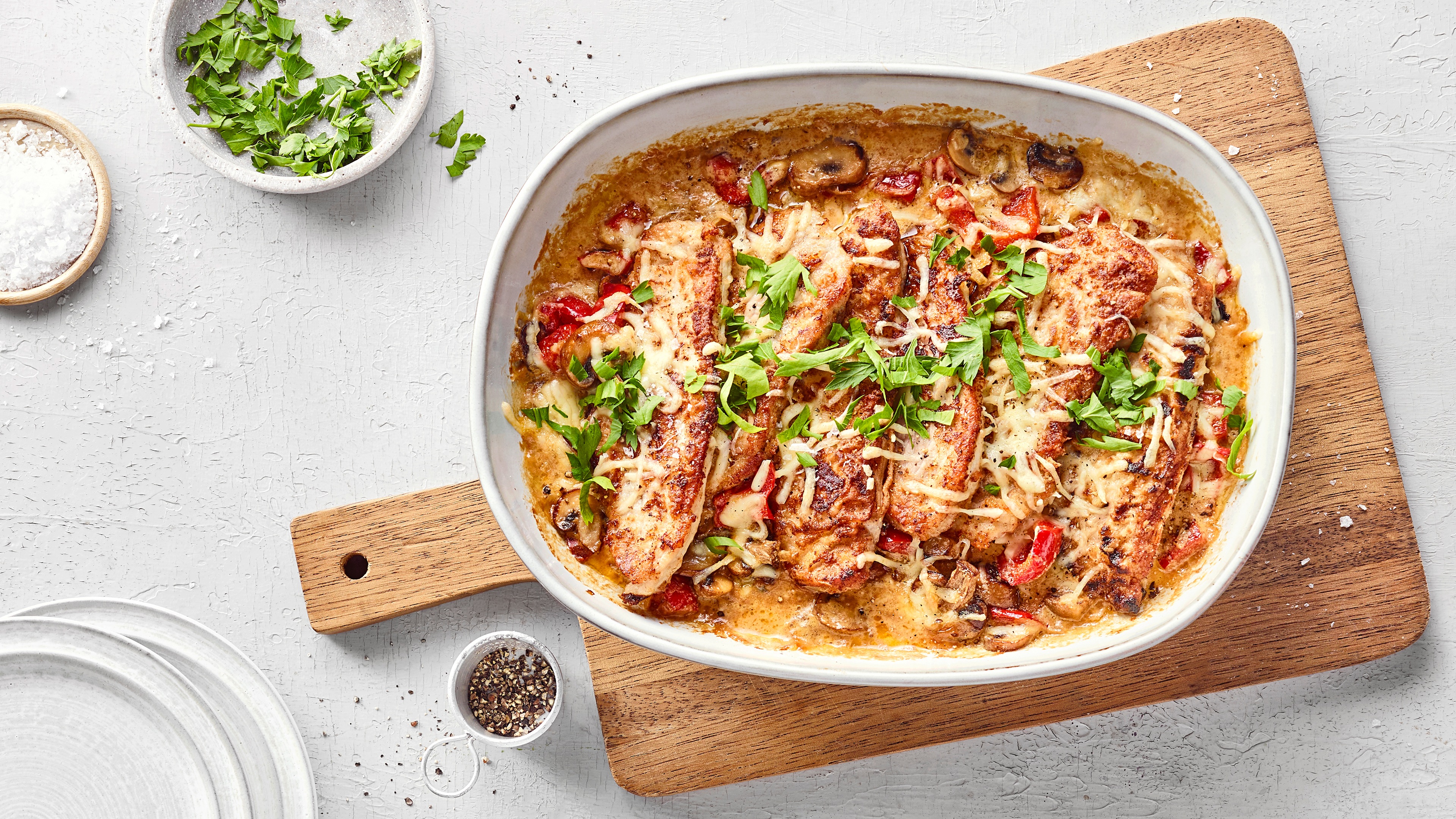 Schnitzelauflauf mit panierten Schnitzelstücken, cremiger Sauce, Gemüse und geschmolzenem Käse, goldbraun überbacken.