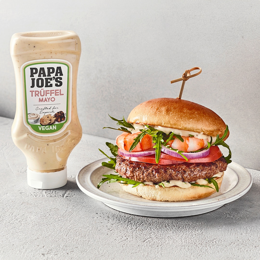 Burger mit Patty, Tomaten und Garnelen auf Teller, daneben Papa Joes Trüffelmayonnaise