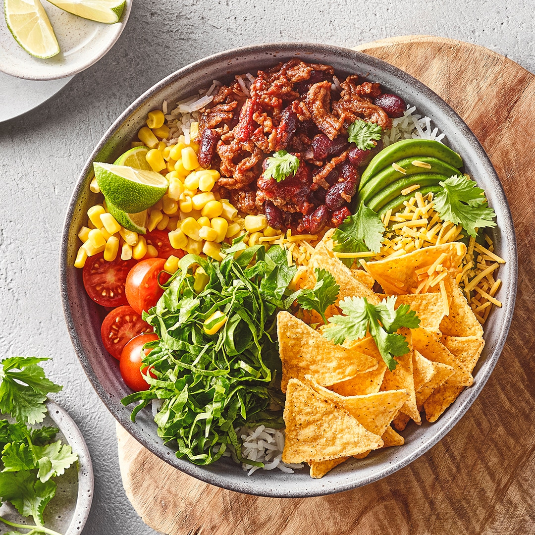 Große Schale mit Hackfleisch, Mais, Tomaten, Avocado und Taco-Chips
