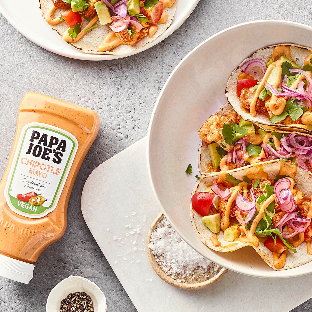 Offene Tacofladen mit Zwiebeln, Blumenkohl, Kräutern und Soße, daneben Papa Joe's Chipotle Mayonnaise