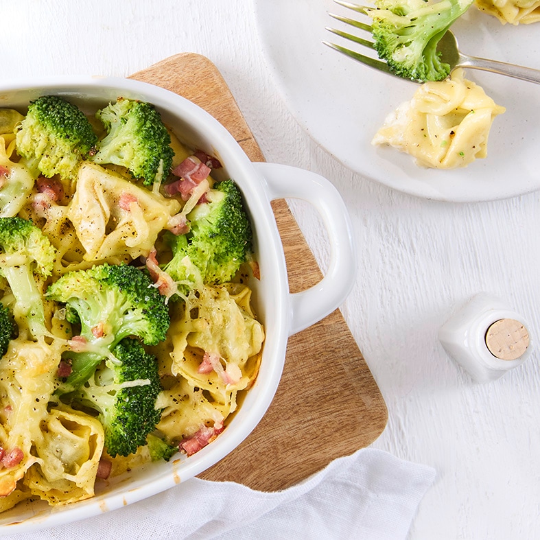 Tortellini-Auflauf mit Brokkoli, Schinken und cremiger Käsesoße in einer Auflaufform.