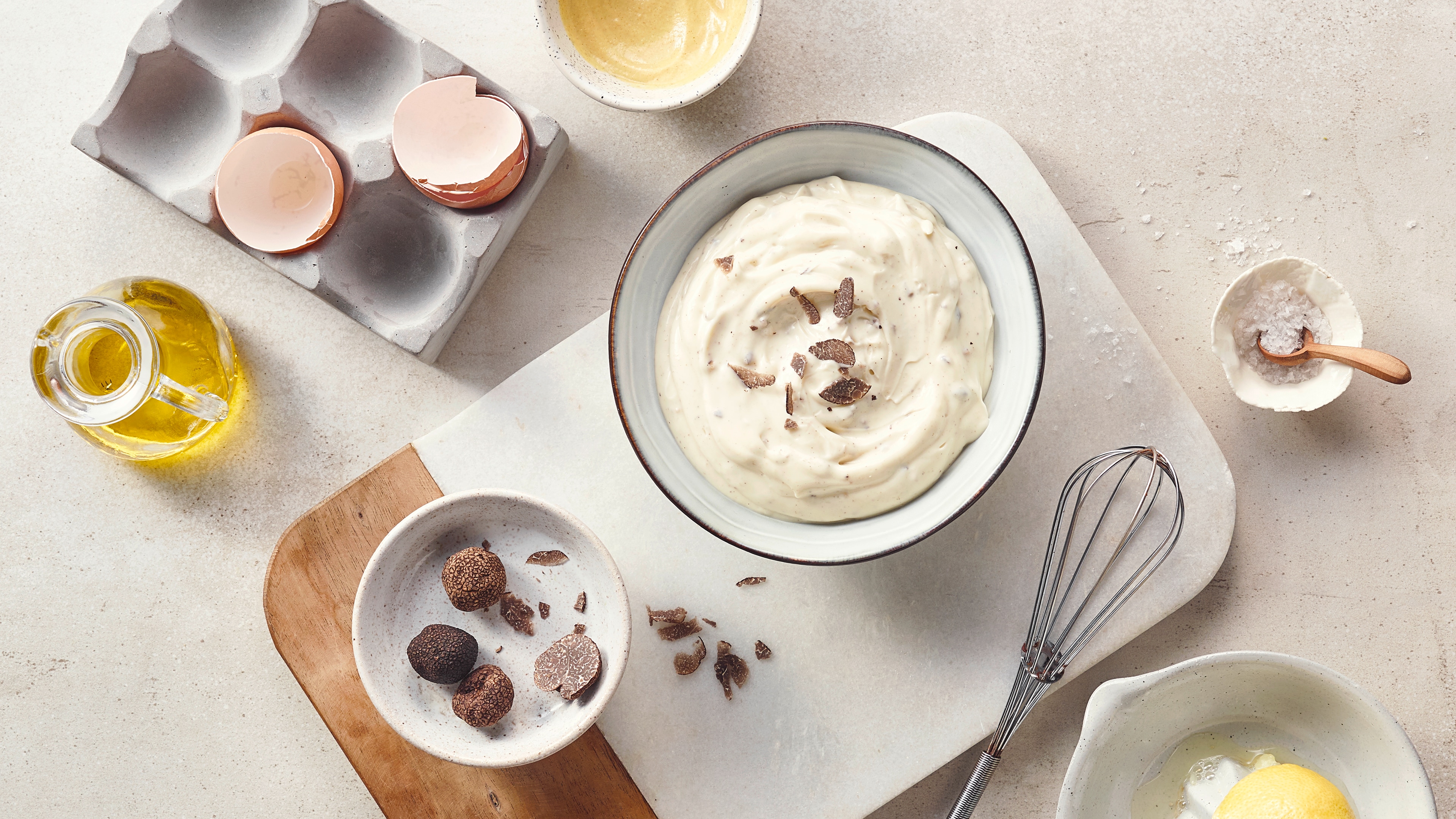 Eine Schüssel mit cremiger, weißer Masse und darauf verstreuten Trüffelstückchen