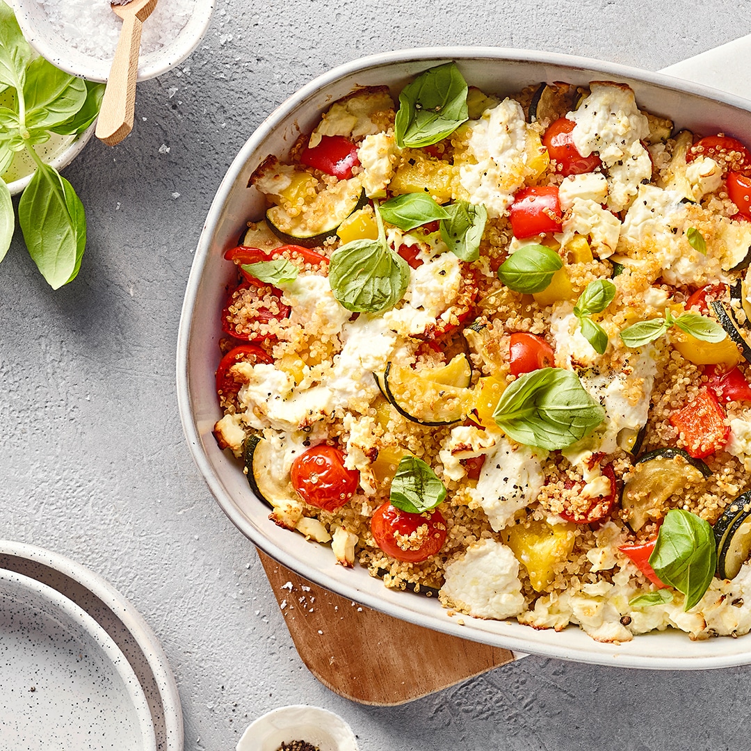 Bunter Auflauf mit körnigem Getreide, Zucchini, Cherrytomaten, Feta und frischem Basilikum.
