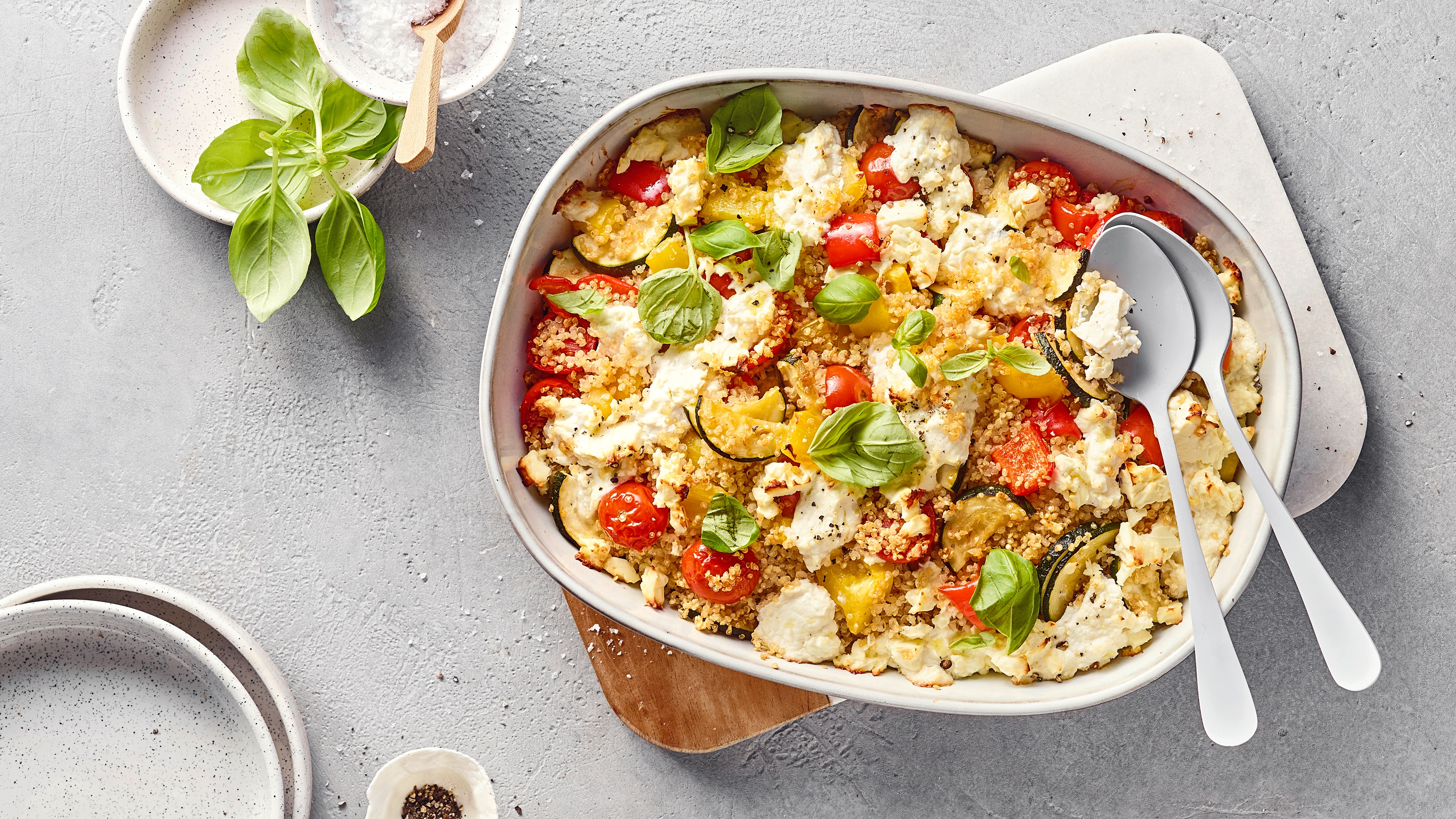 Bunter Auflauf mit körnigem Getreide, Zucchini, Cherrytomaten, Feta und frischem Basilikum.