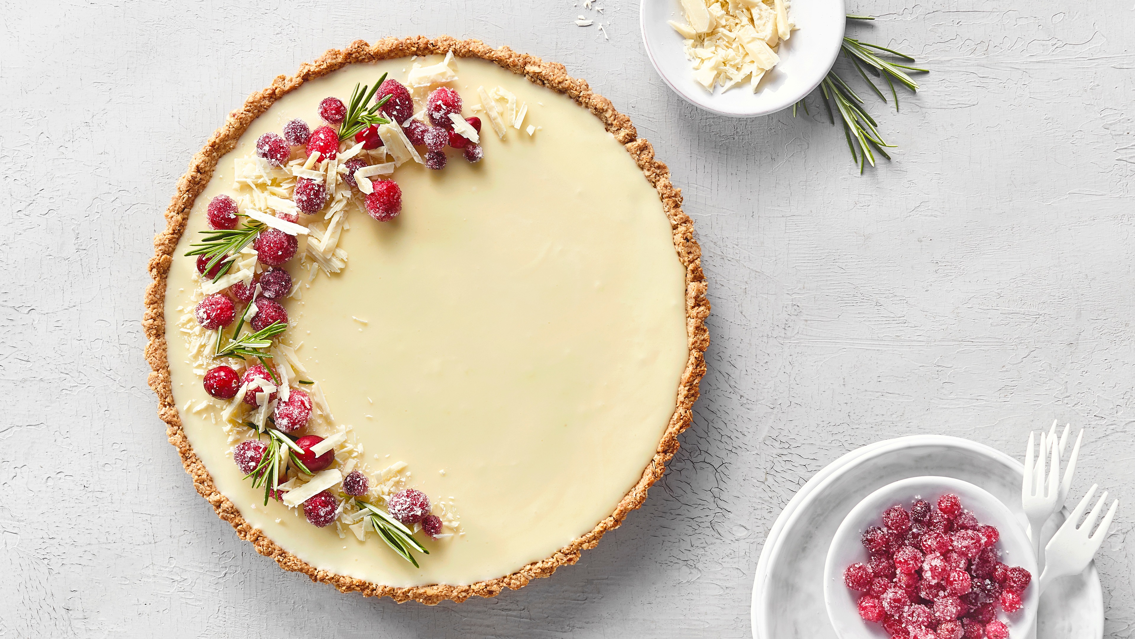 Heller Schokoladentarteboden mit weißer Schokocreme und roten Cranberries obenauf.
