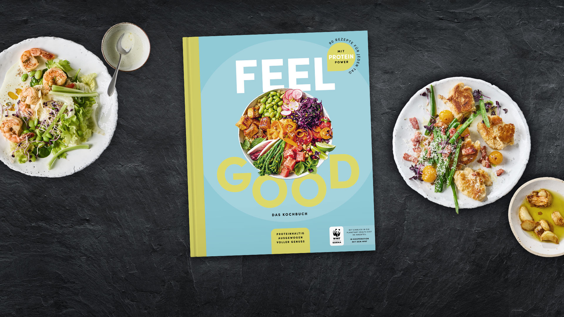 Kochbuch „Feel Good“, umgeben von Tellern mit verschiedenen Speisen.