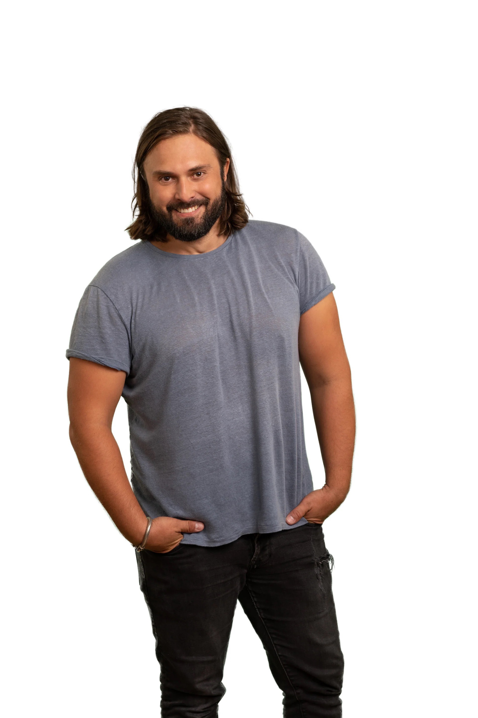 Portrait von Achim Sam. Er hat lange braune Haare sowie einen Vollbart und trägt ein graues T-Shirt.