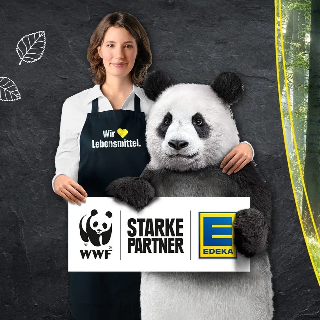 Frau in EDEKA-Kleidung hält mit einem Panda ein Schild mit Text: WWF, starke Partner, EDEKA.