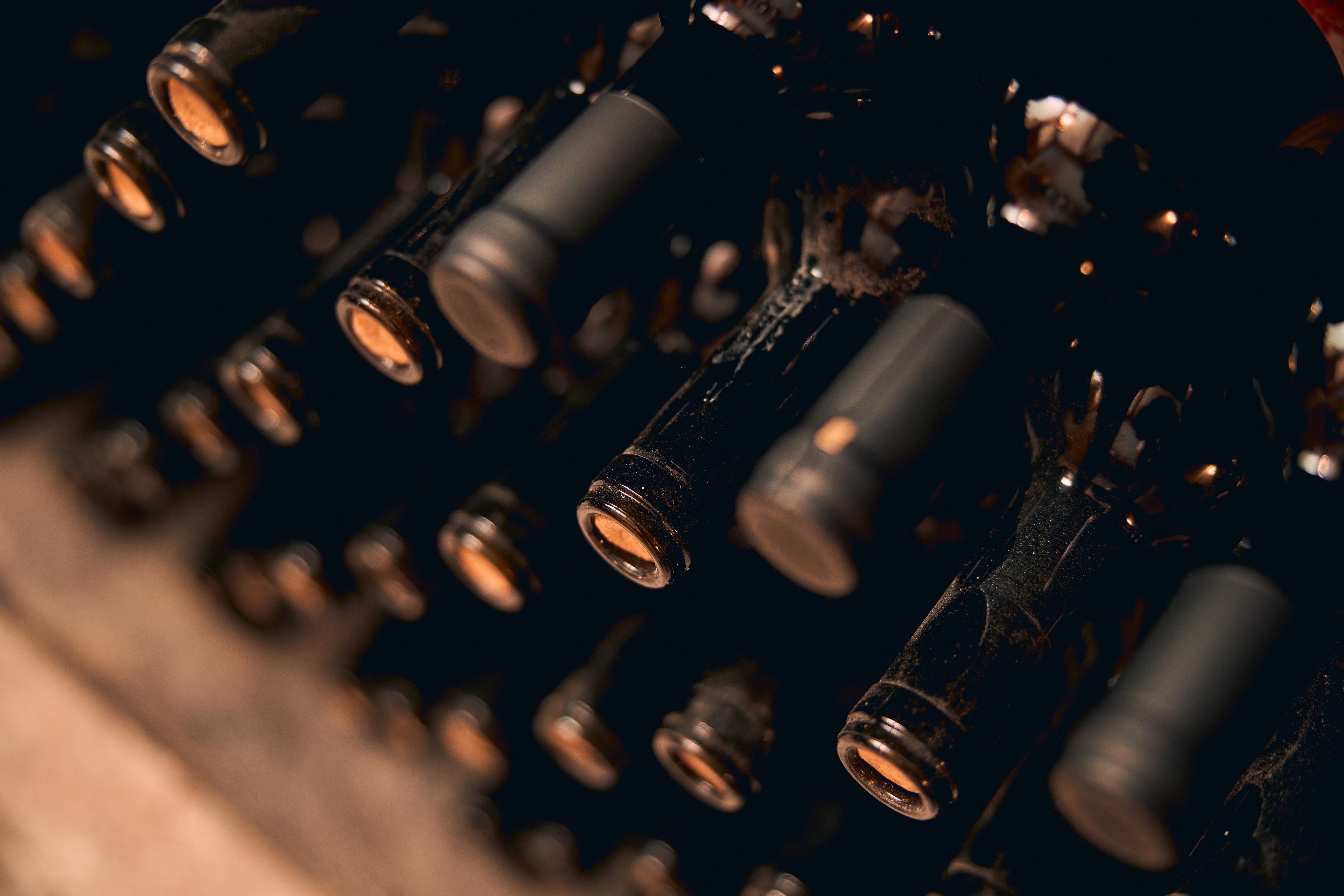 Nahaufnahme mehrerer gelagerter Flaschen Wein.