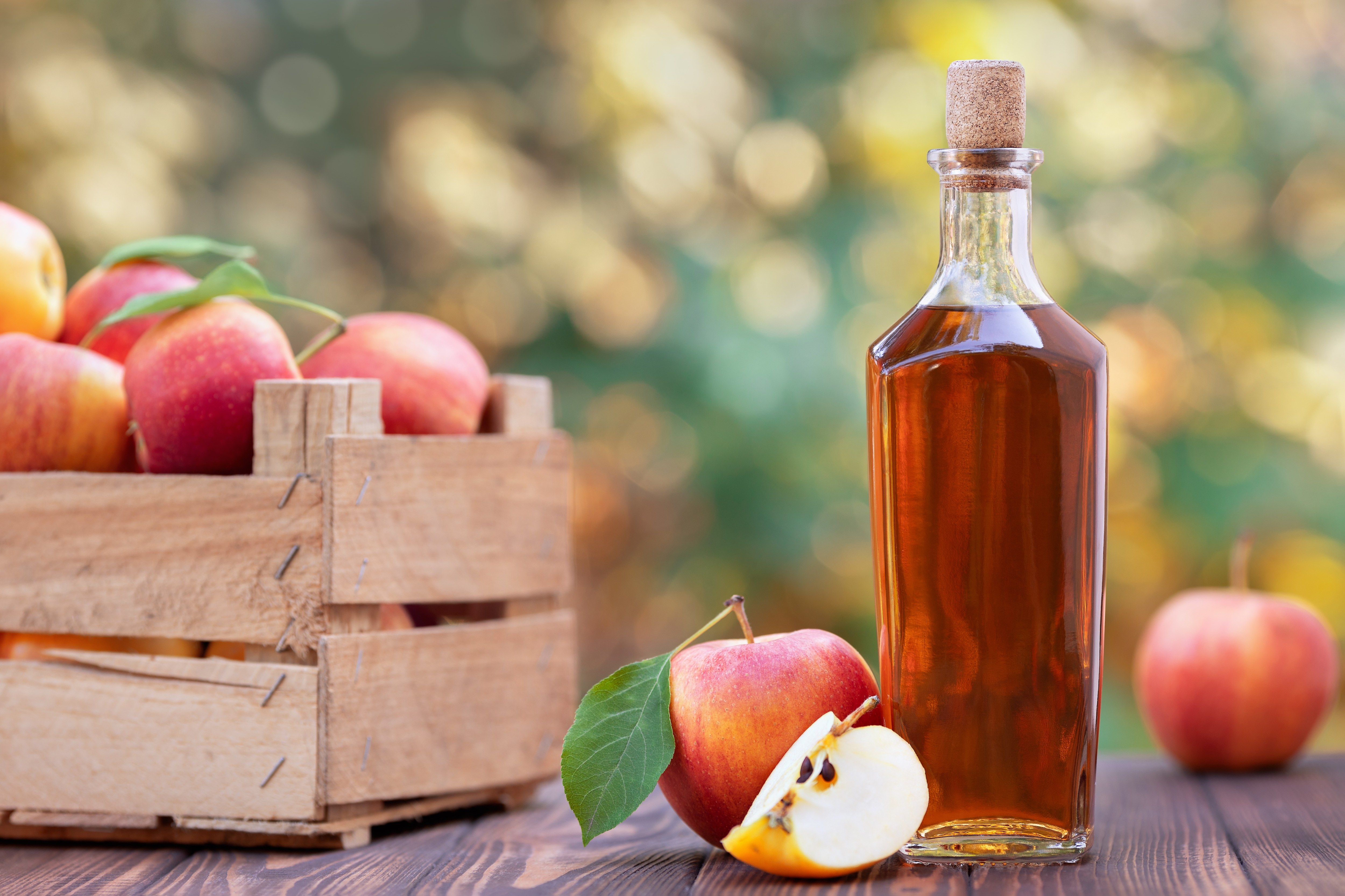 Flasche Apfelwein und eine Kiste mit Äpfeln