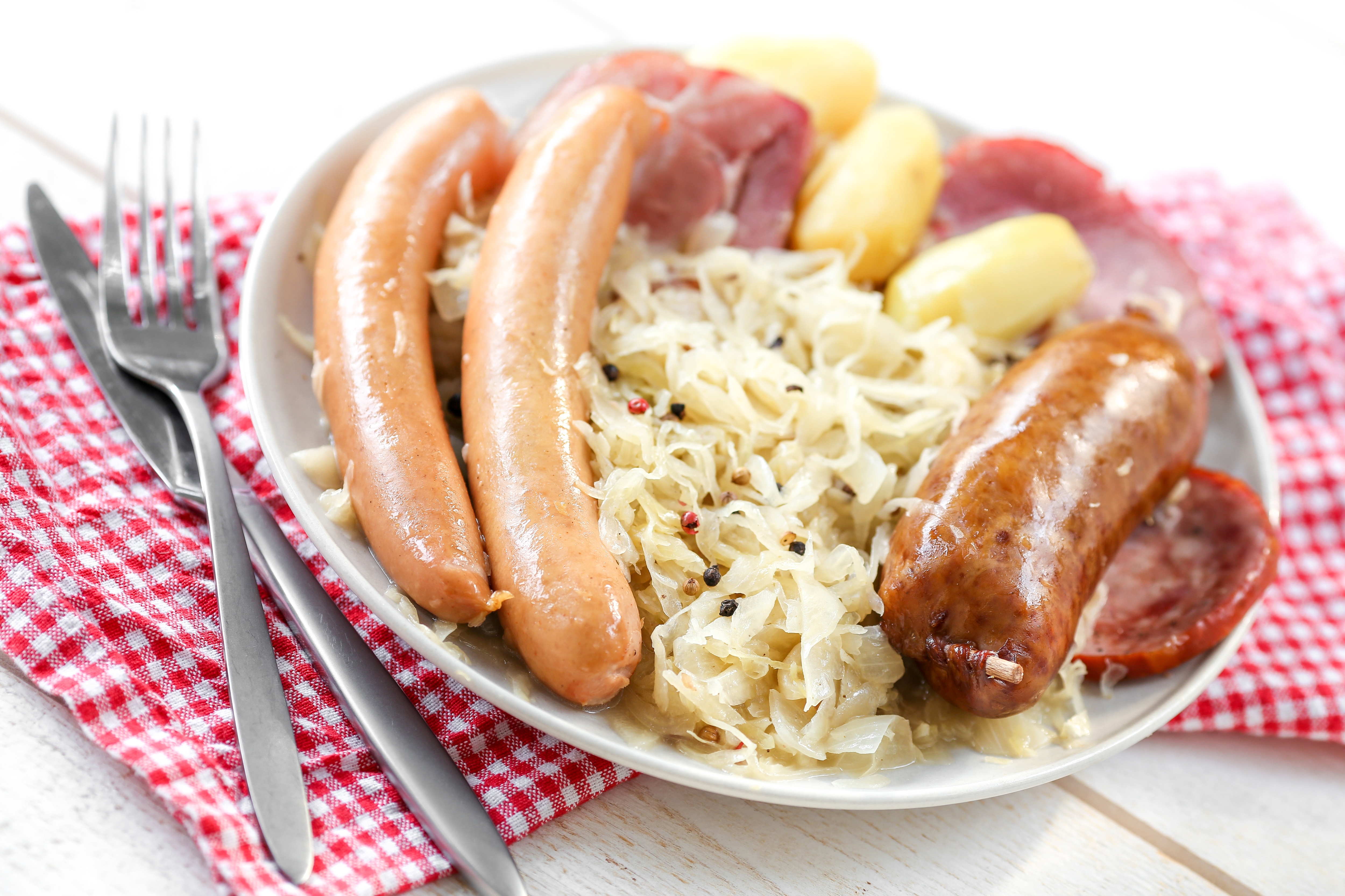 Knackwurst mit Sauerkraut und Kartoffeln auf Teller
